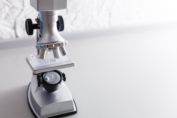 microscope stands on a table on a white background