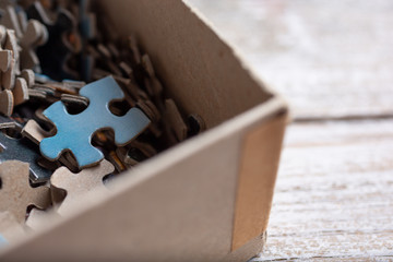 A closeup view of a blue puzzle piece in a box.