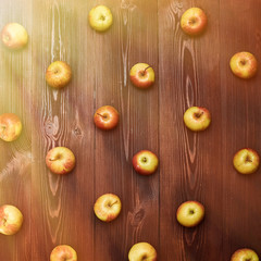 Fresh apples arranged systemically on a wooden background.
