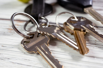 A closeup view of house and car keys on a wooden surface.