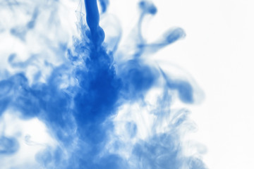 Puffs of paint in water. The dissolution of the dye in water. Water pollution. Concept art creativity.