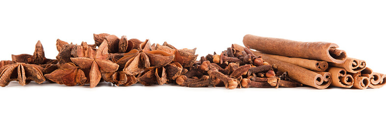 Cinnamon dry sticks and cloves spice pile isolated on white background