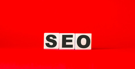 SEO text on wooden cubes and red background