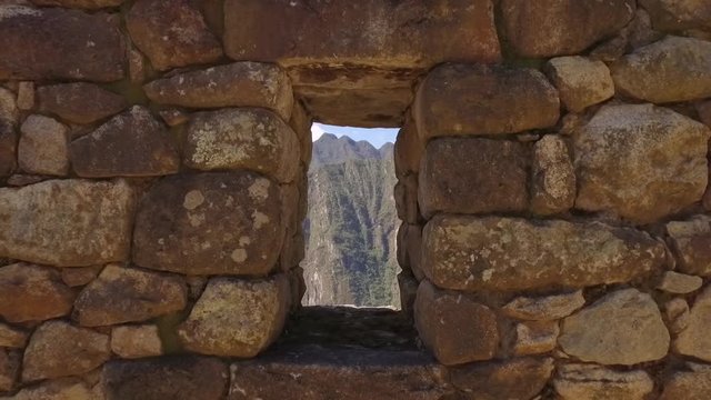 Dolly in Looking at mountains through stone window. Machu Picchu, Cusco, Peru
