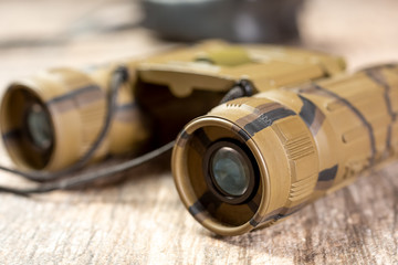 A closeup view of a pair of binoculars with a camouflage design.