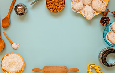 Baking background with sugar, cookies, almounts, baking dishes, wooden spoons. rolling and baking pin. Background layout with free text space. Top view, flat lay style pastry, confectionery.