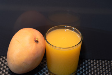 Mango juice (Mangifera indica) on dark background