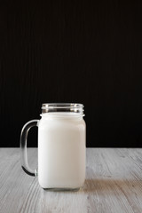 Coconut milk in a glass jar mug, side view. Copy space.