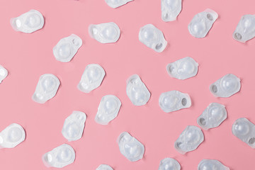 A lot of blisters with contact lenses interspersed on a pink background. Blisters are new and not...