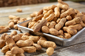 A view of a metal tray full of peanuts.