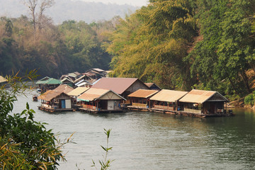 Fototapeta na wymiar Traditional style cottages on the rafts floating in the river in the middle of the forest