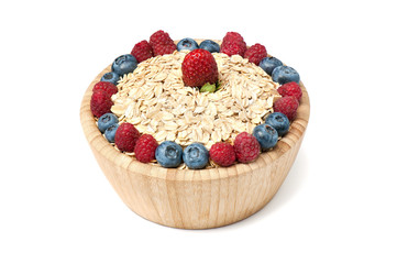 Breakfast cereal with blueberry, raspberry and strawberry in wooden bowl over white background.