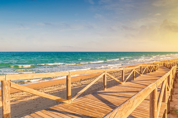 long wooden bridge over the sand to access the beach in Guardamar beach. Alicante, Spain
