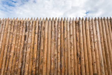 pointy wooden fence against the sky
