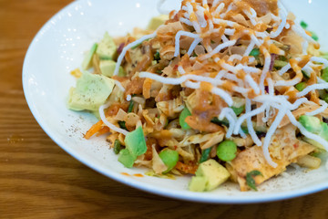 Vegetarian food, Avocado salad with crunchy noodles and fried chips on top.