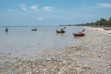 Boats floating on sea with a lot of plastic bottle and garbage on dirty beach - water environment pollution concept