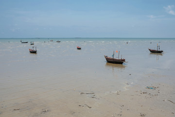 Many small boats aground on the beach with blue sky background. Small fishing boats aground on the beach.