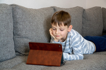 Distance learning online education. School kid using tablet for homework.