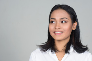 Fototapeta premium Face of happy young beautiful Asian businesswoman thinking