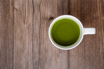 Fototapeta na wymiar cup of matcha green tea on wooden table. Top view. healthy food concept