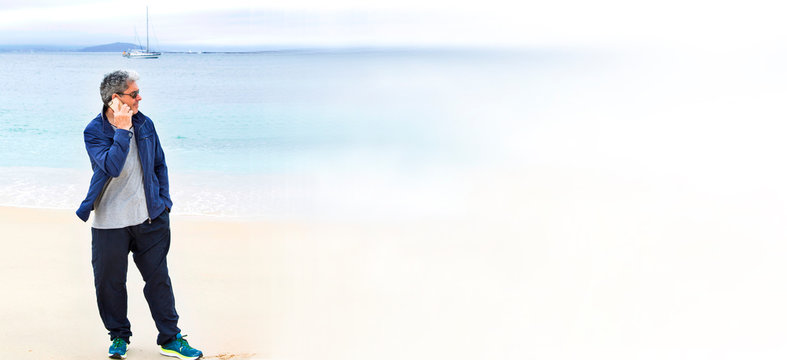 senior man on the beach talking on the mobile phone