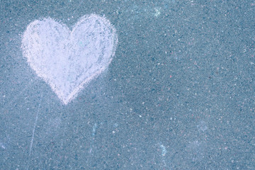 a heart drawn in chalk on the asphalt
