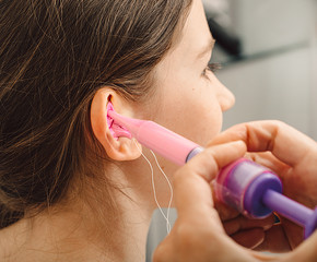 Process of making earplugs from an impression of an individual s child ear. Ear close-up....