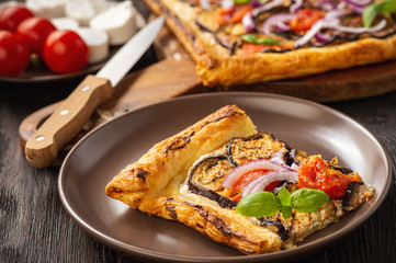 Eggplant tart with tomatoes , red onion and cheese.