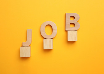 Flat lay composition with word JOB on orange background. Career concept