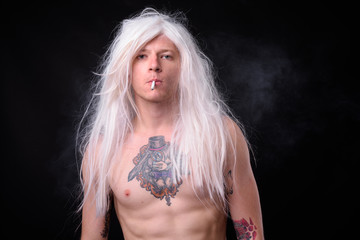 Punk rocker man wearing wig against black background