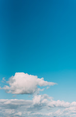 white clouds in a blue sky. Bright day, vertical photography