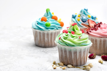 Colorful cupcakes with different modern decoration on light grey background. close up view