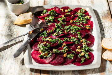 Beetroot carpaccio with walnuts and herbs dressing.