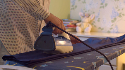 Male hand ironing trousers