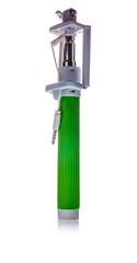 Green selfie stick for taking self portraits with camera on smartphone isolated on white background. Modern technology and social media concept.