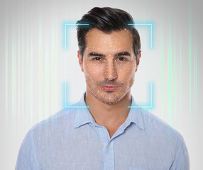 Facial recognition system. Young man with scanner frame and digital biometric grid on light...
