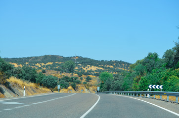 Carretera frente a una montaña llena de arboles en Huelva, España. 