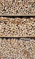 Precisely layered pile of wood from different cut firewood, heating material, sustainable reforestation