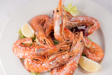 Plate of grilled jumbo shrimp with lemon and endive.