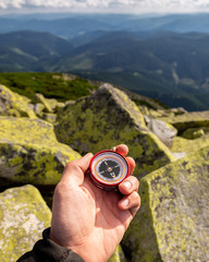Compass in the hands in the Carpathian mountains. Traveling in the mountains. © Sergii