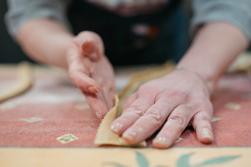 The process of making homemade Italian pasta. Italian woman preparing homemade pasta in the kitchen, close-up on hands. Different focus