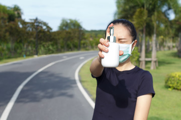 Young woman in medical protective mask and holding an alcohol in hand. campaign to use protective mask and alcohol  for protect COVID19