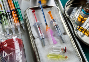 Diverse medication in glasses monodose along with insulin injectors in hospital, conceptual image