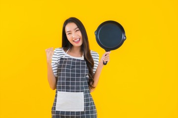 Portrait beautiful young asian woman  wear apron with black pan and Spatula