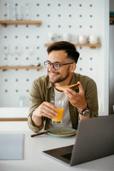 Handsome man eating breakfast at home. Happy man enjoying in morning.