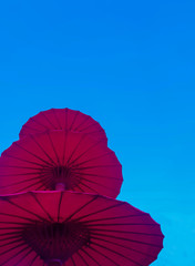 Red bamboo umbrella on sky background