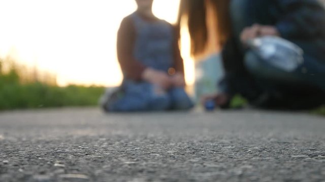 A little boy and his mom lounch a toy car and it rides and crashes into the camera