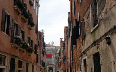 Fototapeta na wymiar Cityscape with historical facades with flowers and shutters in Venice.