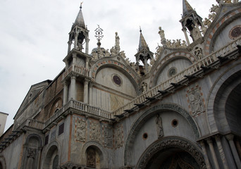Obraz premium Marble facade of St. Mark's Cathedral with mosaics, sculptures in Venice in sunny summer day.