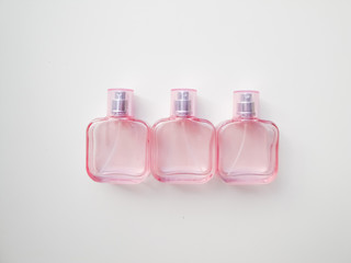  Set of colored cosmetic bottles, ampoules, tubes, cans on a white background. Pink bottles with flowers, aroma concept